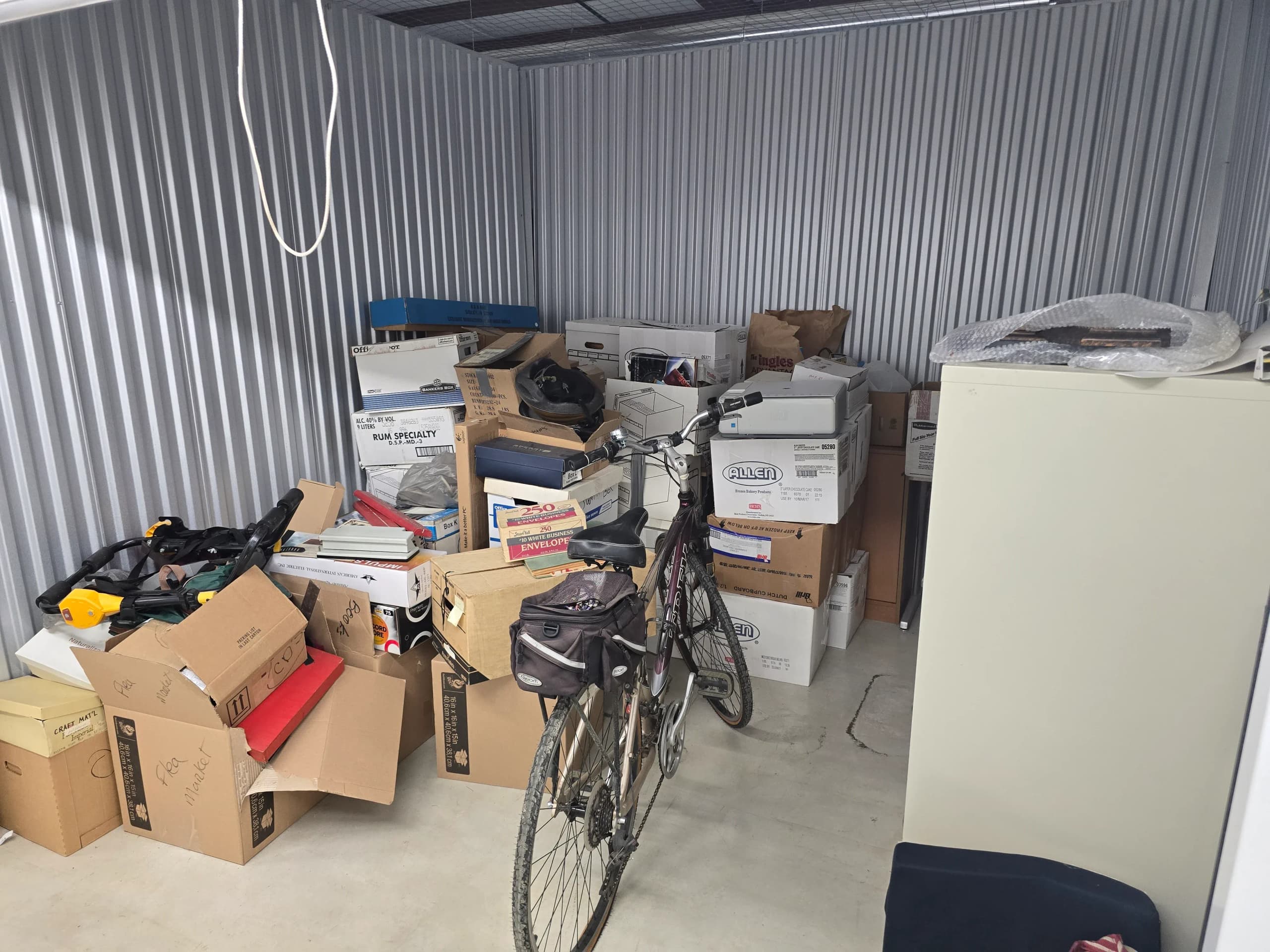 Bicycle, cardboard boxes, and a filing cabinet filling a metal storage unit in Kingsport, TN
