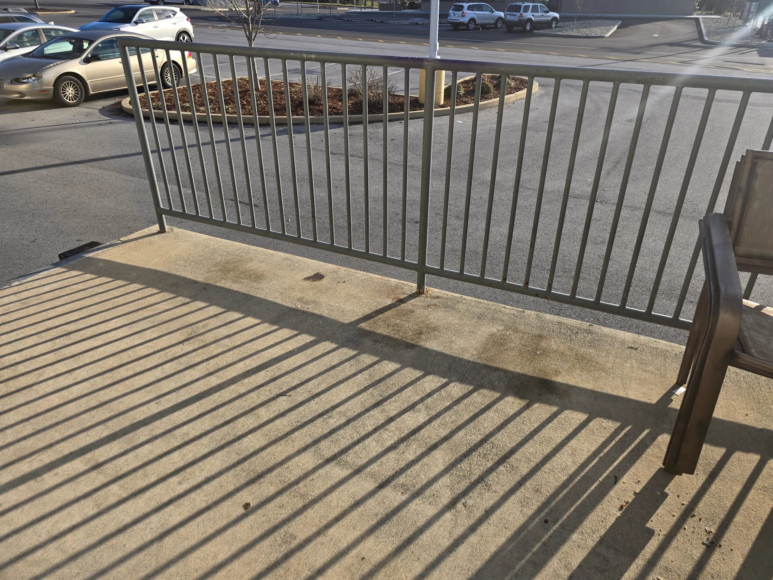 Empty concrete walkway beside a metal railing after trash bags were cleared in Johnson City, TN