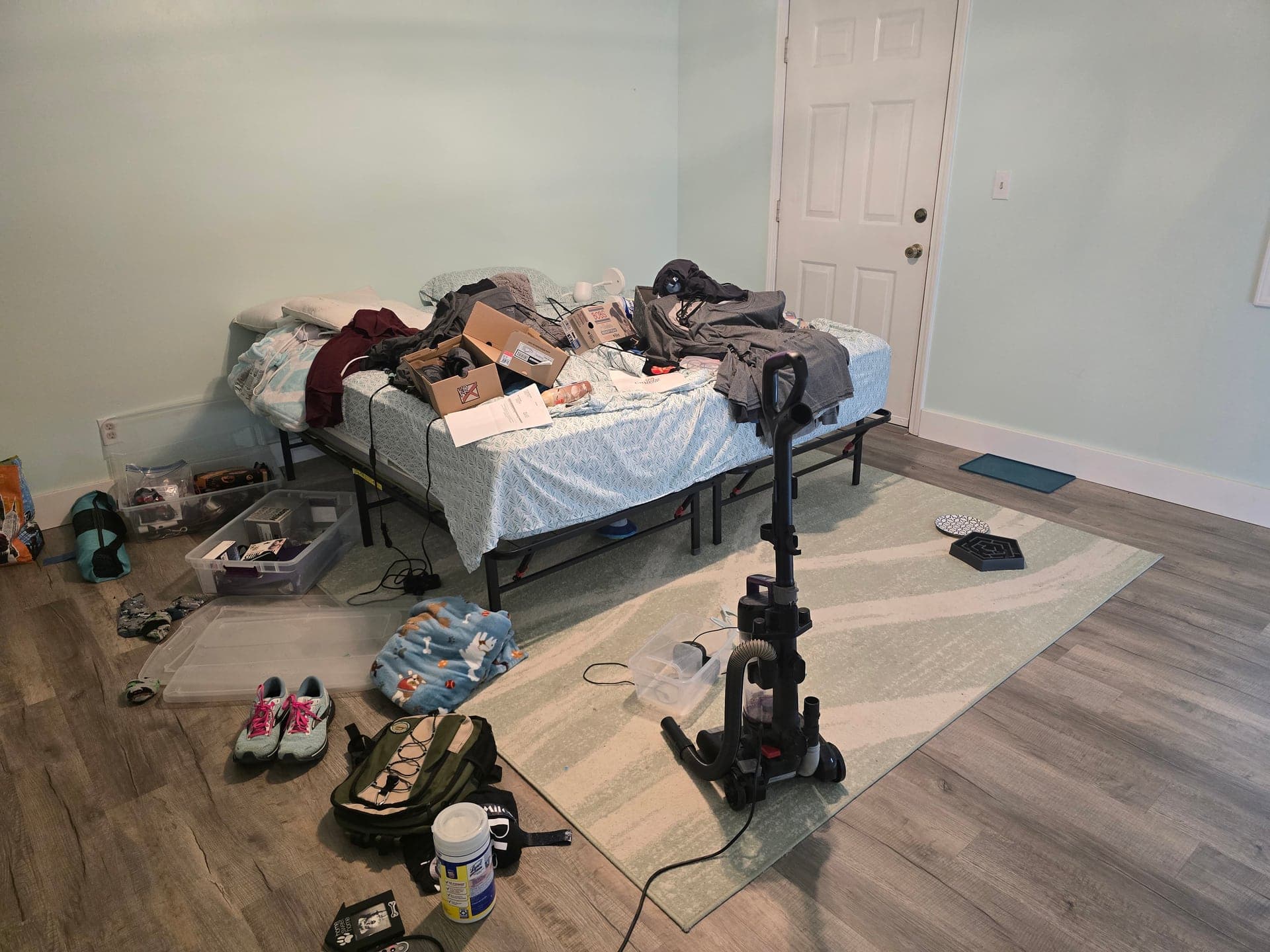 Cluttered bedroom with boxes, clothes, and belongings before an estate cleanout in Bristol, TN