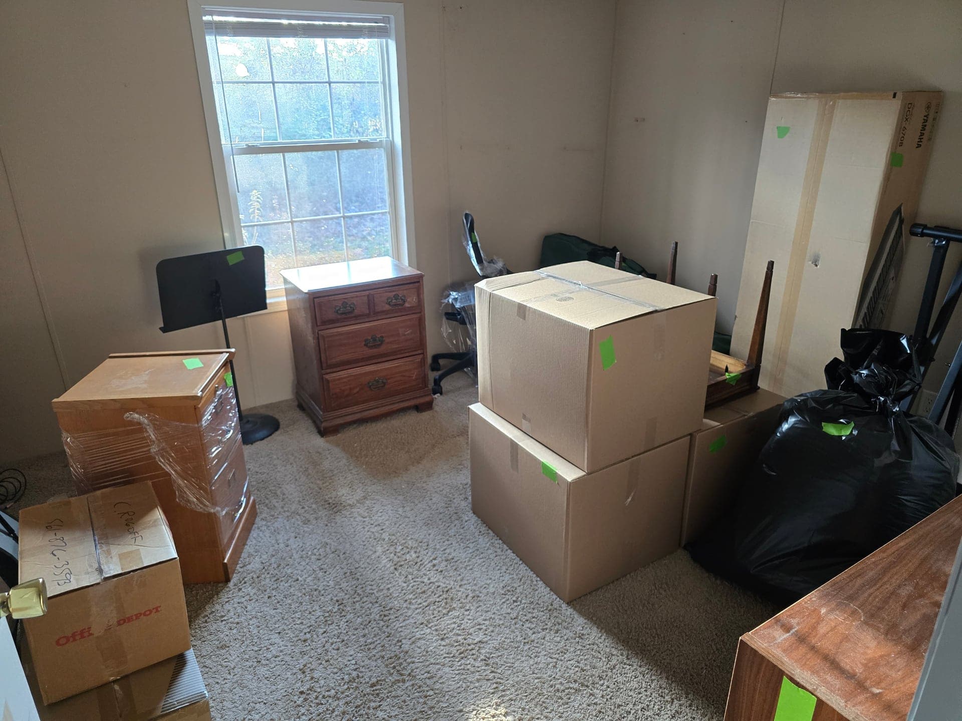 Household furniture, boxes, and trash bags piled in a backyard before an estate cleanout in Johnson City, TN