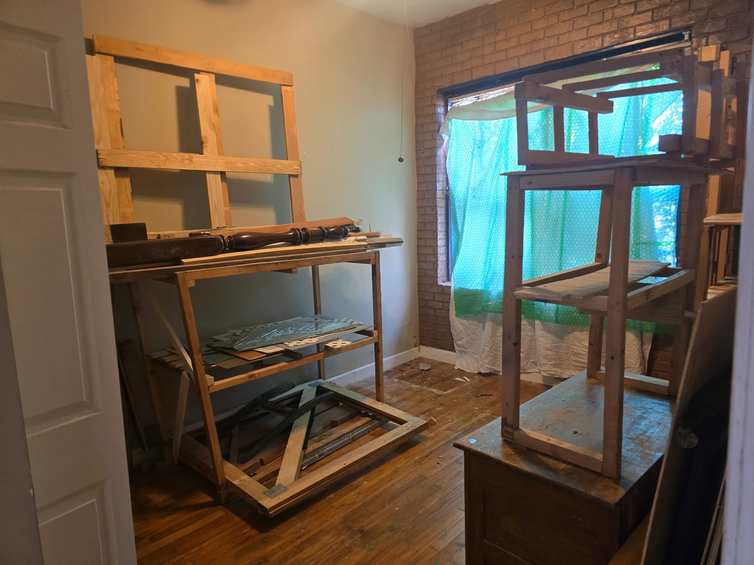 Cluttered room with wooden shelving and debris before a house cleanout