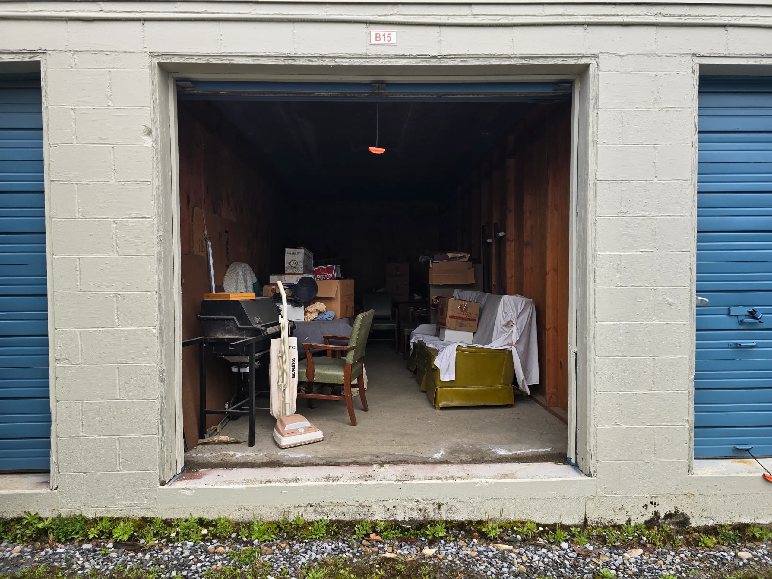Outdoor storage unit B15 filled with furniture and boxes before a cleanout