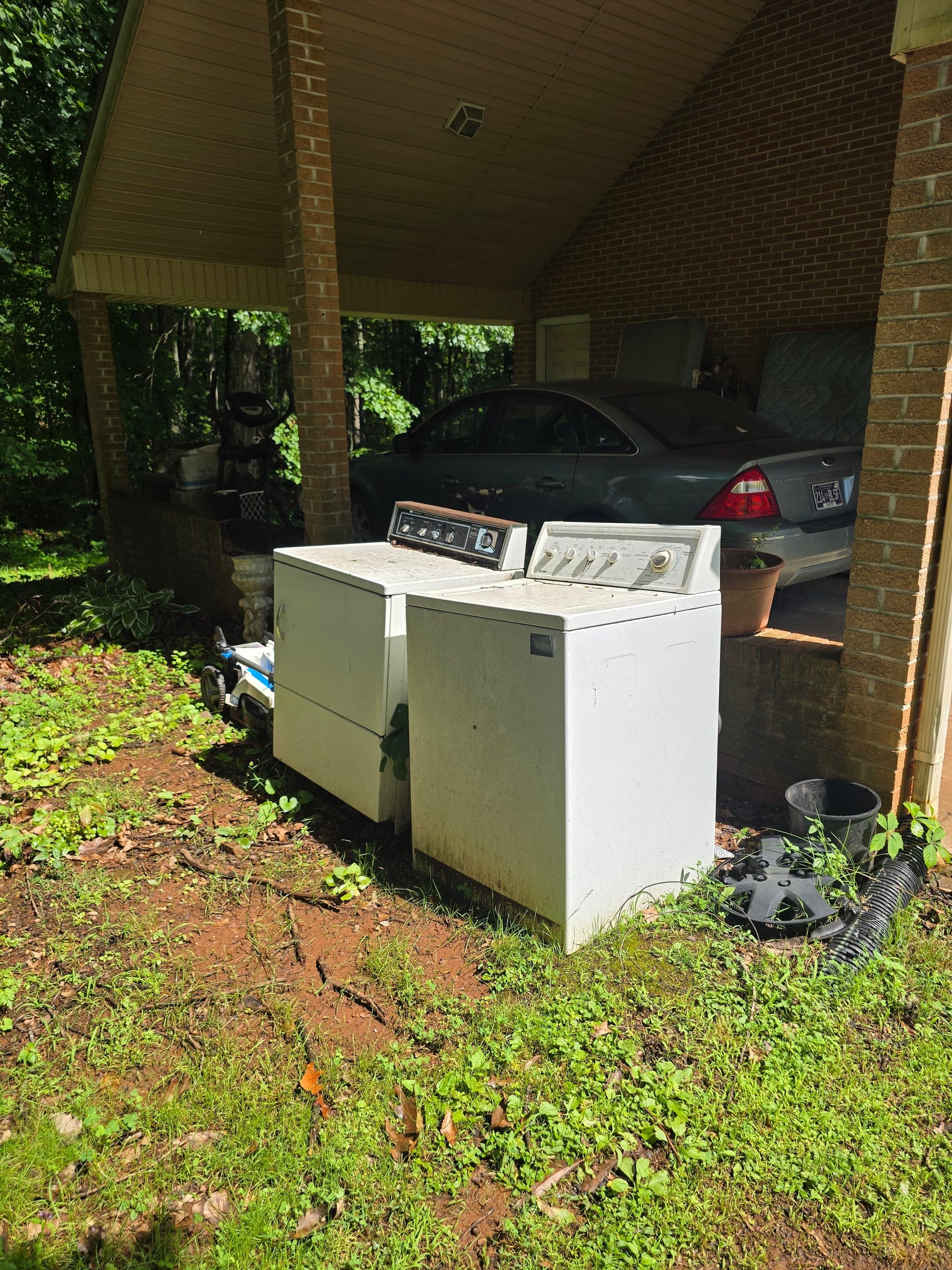 Washer and dryer staged outdoors for appliance removal by Kraken Junk Removal