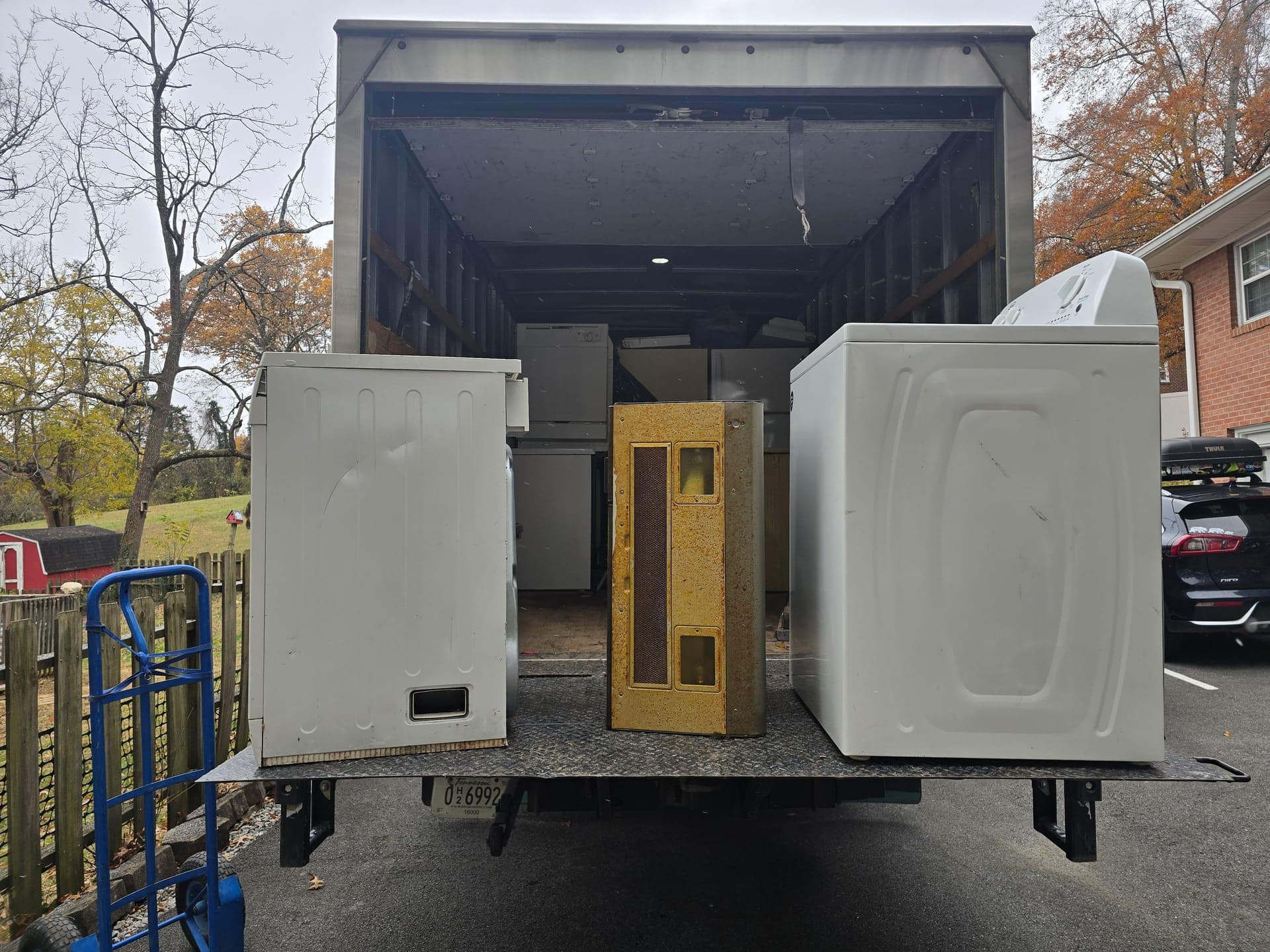 Washing machines and other household appliances loaded on a truck liftgate for removal