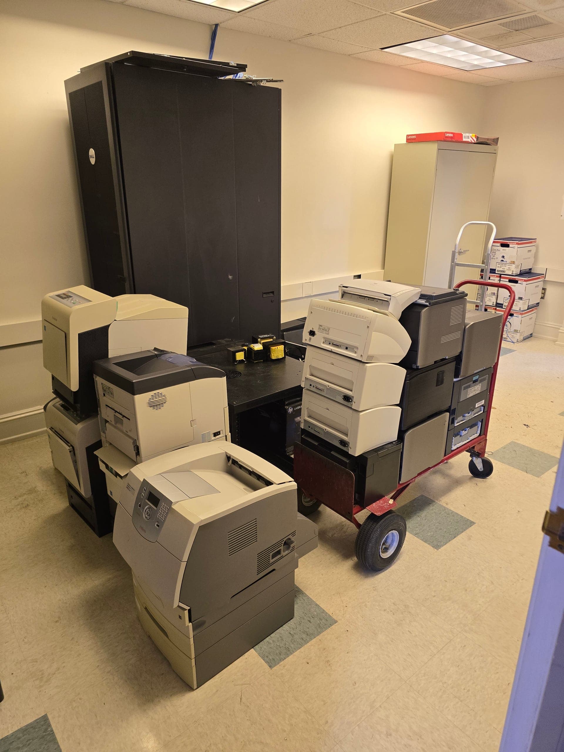 CRT TVs, monitors, speakers, keyboards, cables, and an open computer tower staged for electronics removal and recycling