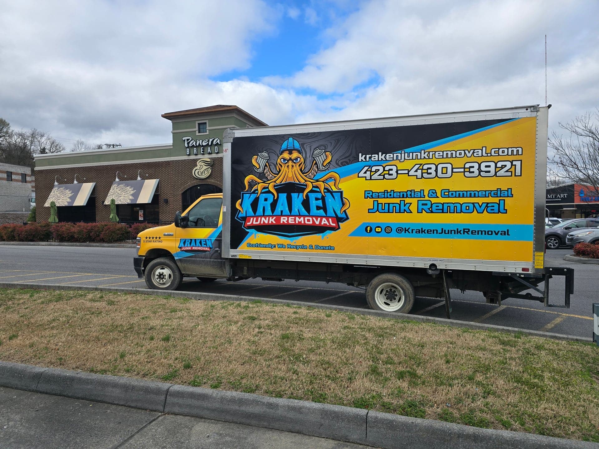 Kraken Junk Removal truck parked at a commercial shopping center