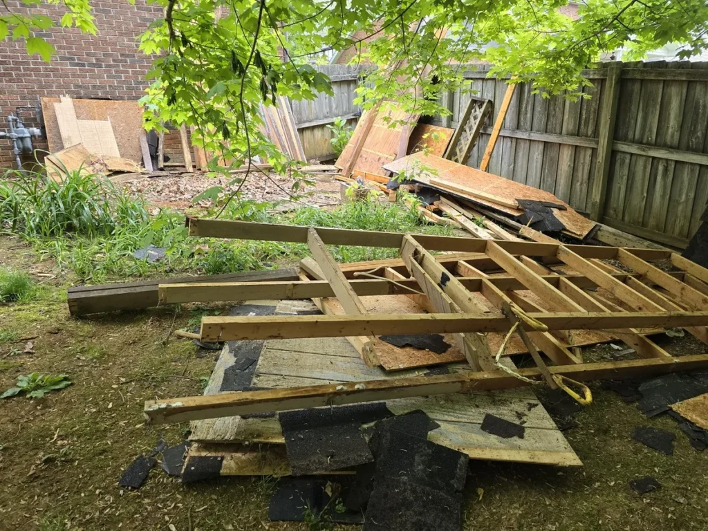 Kraken Junk Removal efficiently handling construction debris removal in a Tri-Cities, TN backyard, showcasing piles of dismantled wood and building materials ready for cleanup.