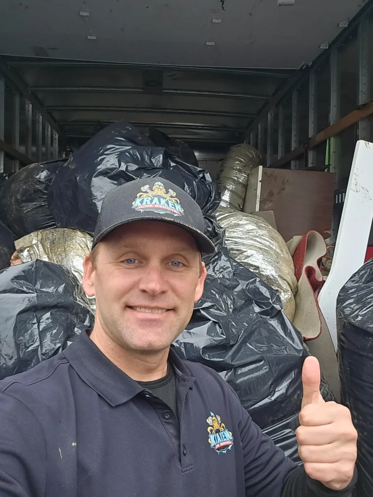 Kraken Junk Removal team member standing in front of box truck full of junk, trash and garbage in Telford, TN