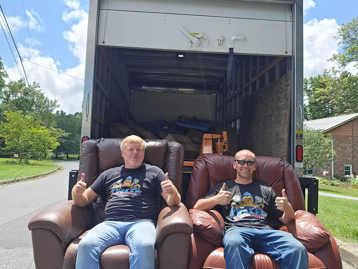 Kraken Junk Removal team sitting on furniture in front of truck during a residential junk removal job in Telford, TN.