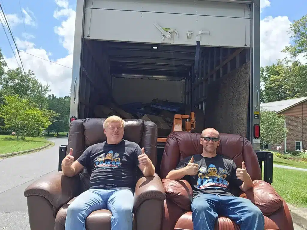 Two Kraken Junk Removal team members posing confidently in uniform after a home cleanout job in Tri-Cities, TN.