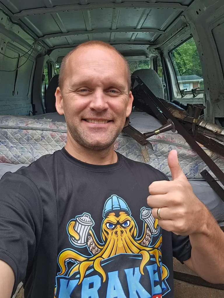 Kraken Junk Removal giving a thumbs up during a residential junk removal job with mattresses in the background, in Tri-Cities, TN.